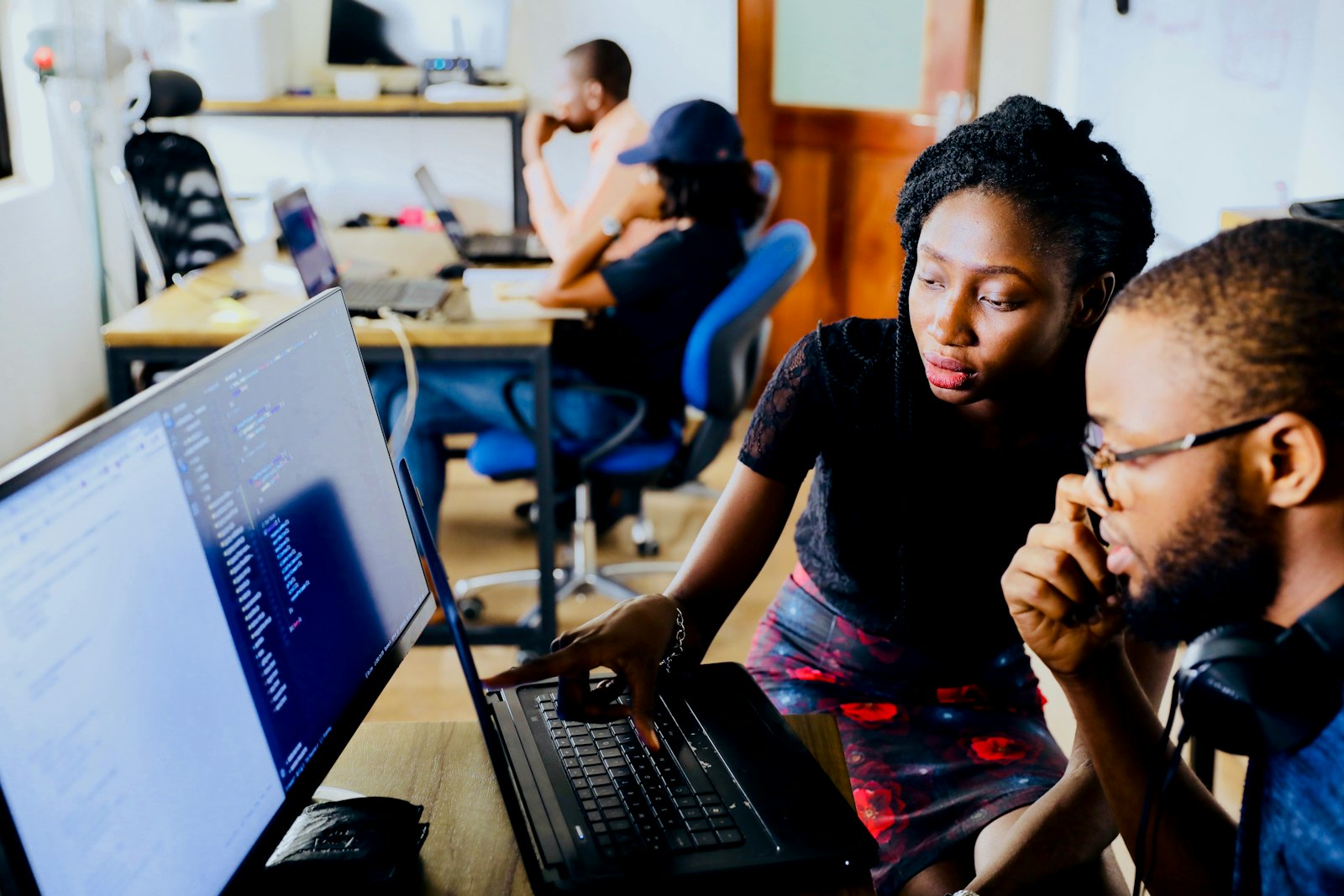 Young Tanzanians working together on laptops during a FODA digital skills session